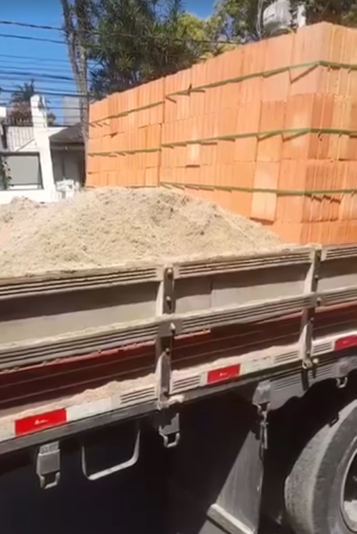 Caminhão carregado: tijolo, areia e material